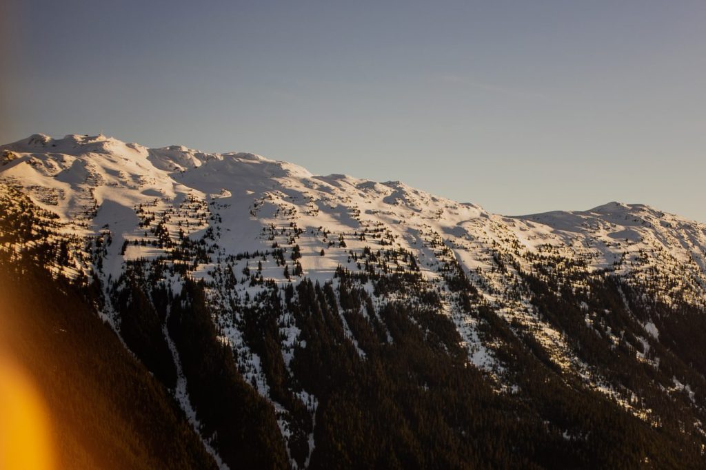 Snow-capped mountains covered in evergreen trees in British Columbia in Canada for blog post titled 10 ways to cope with and work through homesickness.